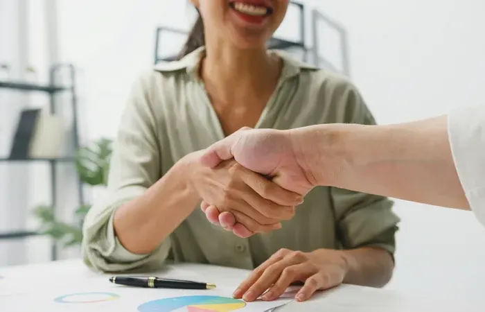 Close-up of two professionals shaking hands during a meeting, symbolizing partnership and success at Town Service World